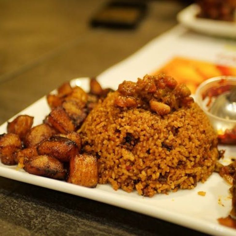 Close-up of West African Jollof rice with fried plantains, ideal for food lovers.